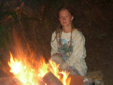 Amy sitting in front of the fire in the Redwood Forest