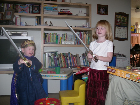 The two older kids sword fighting