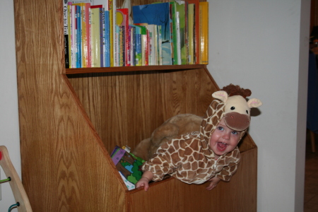 Olivia in her giraffe costume inside her new toy box