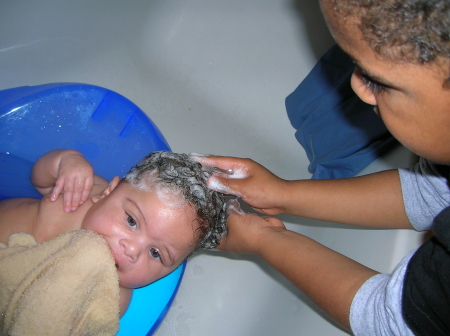 Big brother washing lil sis's hair