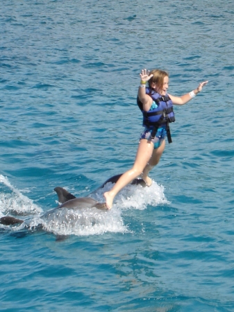 Allie riding the dolphins in Cozumel