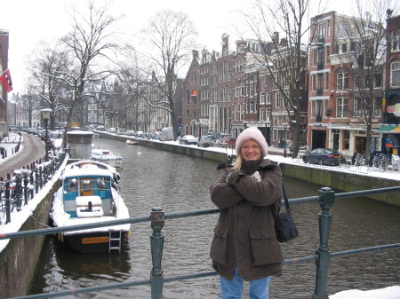 Deb at canal bridge in snowy Amsterdam.