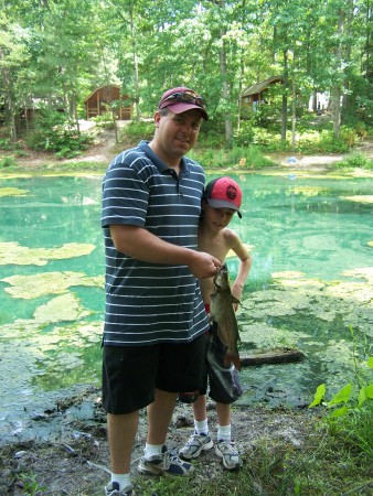 My husband, John, and stepson, Zach, catching a fish while camping.