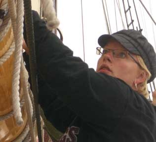 Crewmate Jen furling the mains'l on the Schooner Mary Day