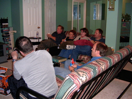 Family watching big screen tv