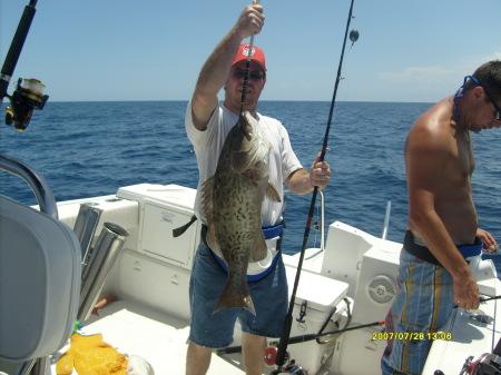 my huband holding his  grouper fish he caught
