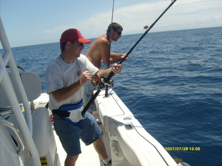 my husband tony reeling in a grouper fish from Panama City Beach in Florida