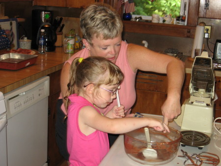 Grandma helping Karolyn mix up her own birthday cake.