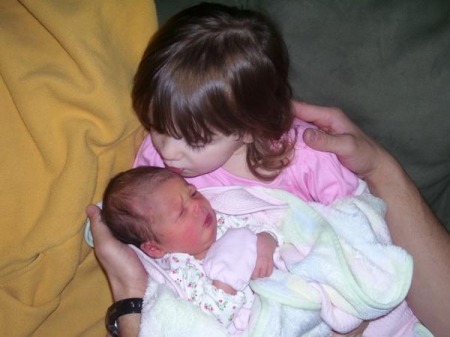 Granddaughter Kendall kissing her new baby sister, Caroline