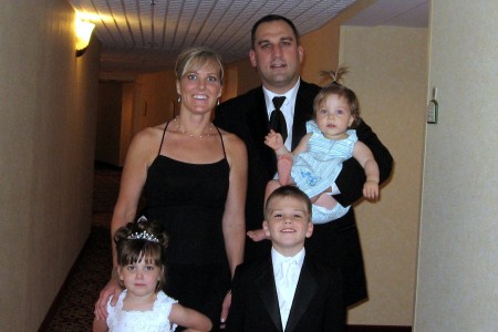 The family all dressed up to be in a wedding.