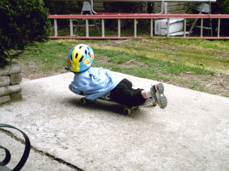 Malachi riding his uncle's skateboard