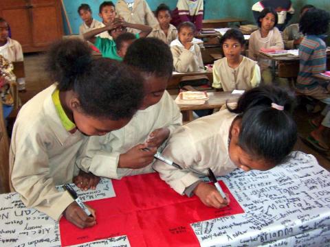 Malagasy Children signing Red Cross Flag
