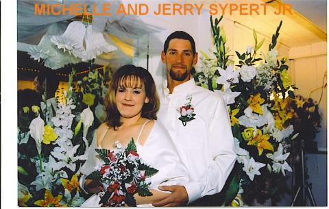 JERRY AND MICHELLE short pose in front of flowers WEDDING