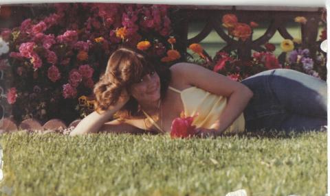 tina at 15 laying w flowers