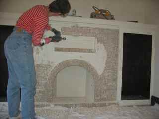 Kim chipping plaster off fireplace