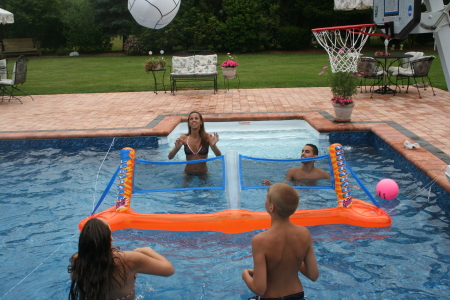 MY KIDS PLAYING VOLLEYBALL IN THE POOL.