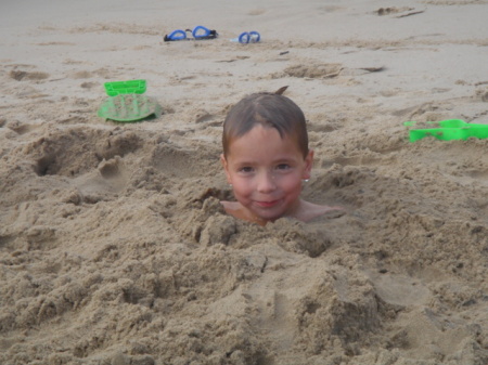 Alex buried in the sand at Lake Michigan