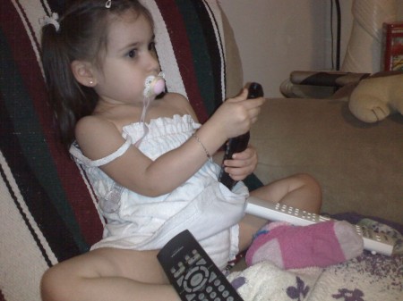 Selena watching tv with all the remotes