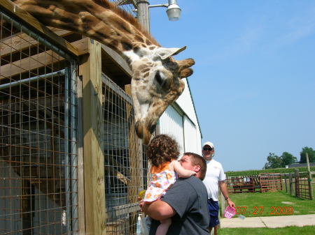 Jacy and daddy petting a giraffe.