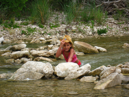 Emily at the creek in Bandera wearing MY hat!