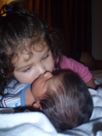 Big sister kissing baby brother