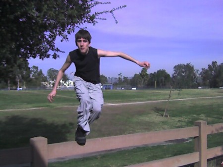 Paul jumping over a fence.