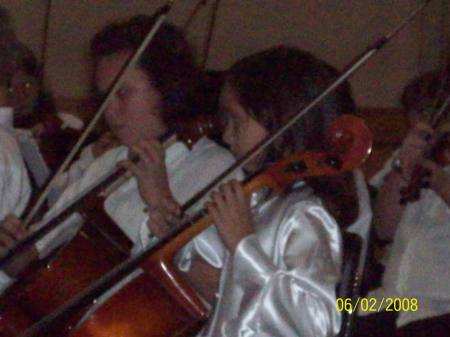 Elizabeth playing the cello in a concert.