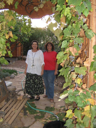 A friend (red) & myself under our grape arbor