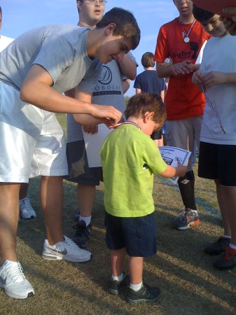 Rush getting award at soccer camp for autism