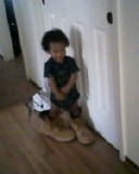 Baby T trying to fit in his daddy's shoes