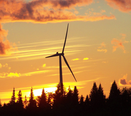 windmill in the sun set behind the cabin