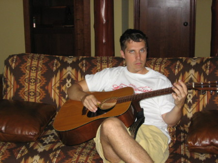 Mark playing guitar at the lake house