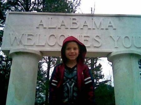 Nolan standing in front of the Alabama Sign