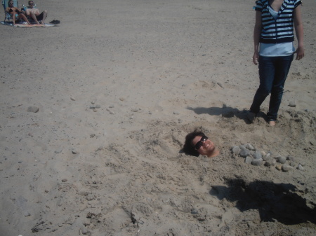 random guy buried in sand