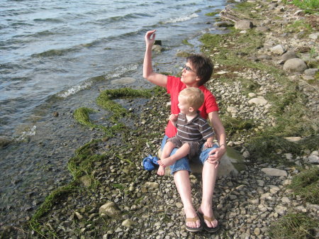 Teaching grandson to skip rocks in the water.