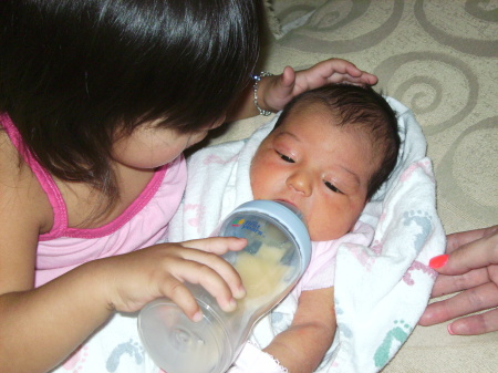 Big sister feeding little sister