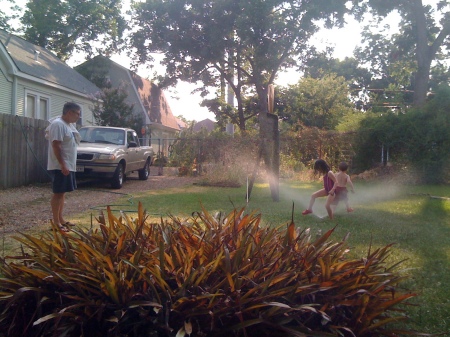 Clara and Diego in the sprinkler