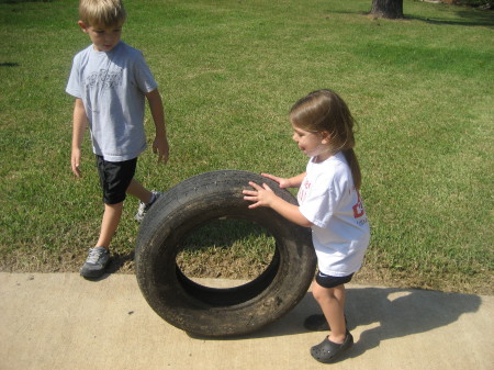 My grandchilder having fun rolling a tire.