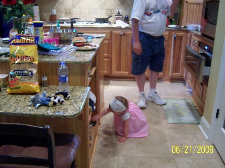 Maci playing in my kitchen, with Jim watching