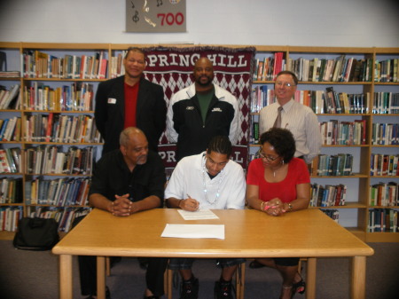 Son signing on a full Basketball Scholarship