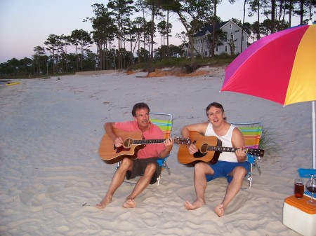 Bob and Mikey playing guitars on the beach