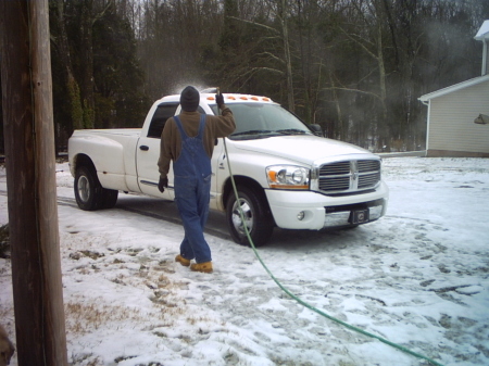 My honey washing my truck in the snow.