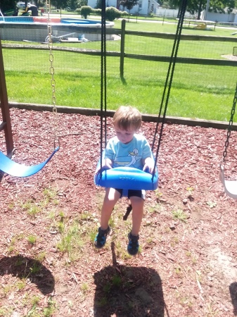 Bently Age 2 in our backyard swing set.