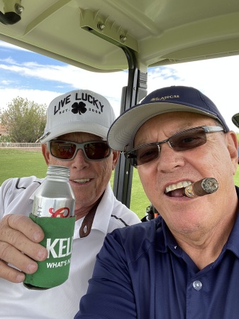 Golf with a buddy and a beer.