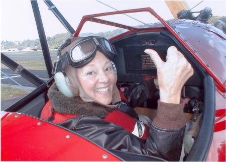 In the open cockpit of a biplane