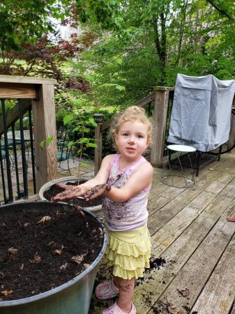 Granddaughter helping plant seeds.