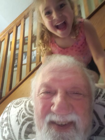 Granddaughter tormenting Pawpaw. 